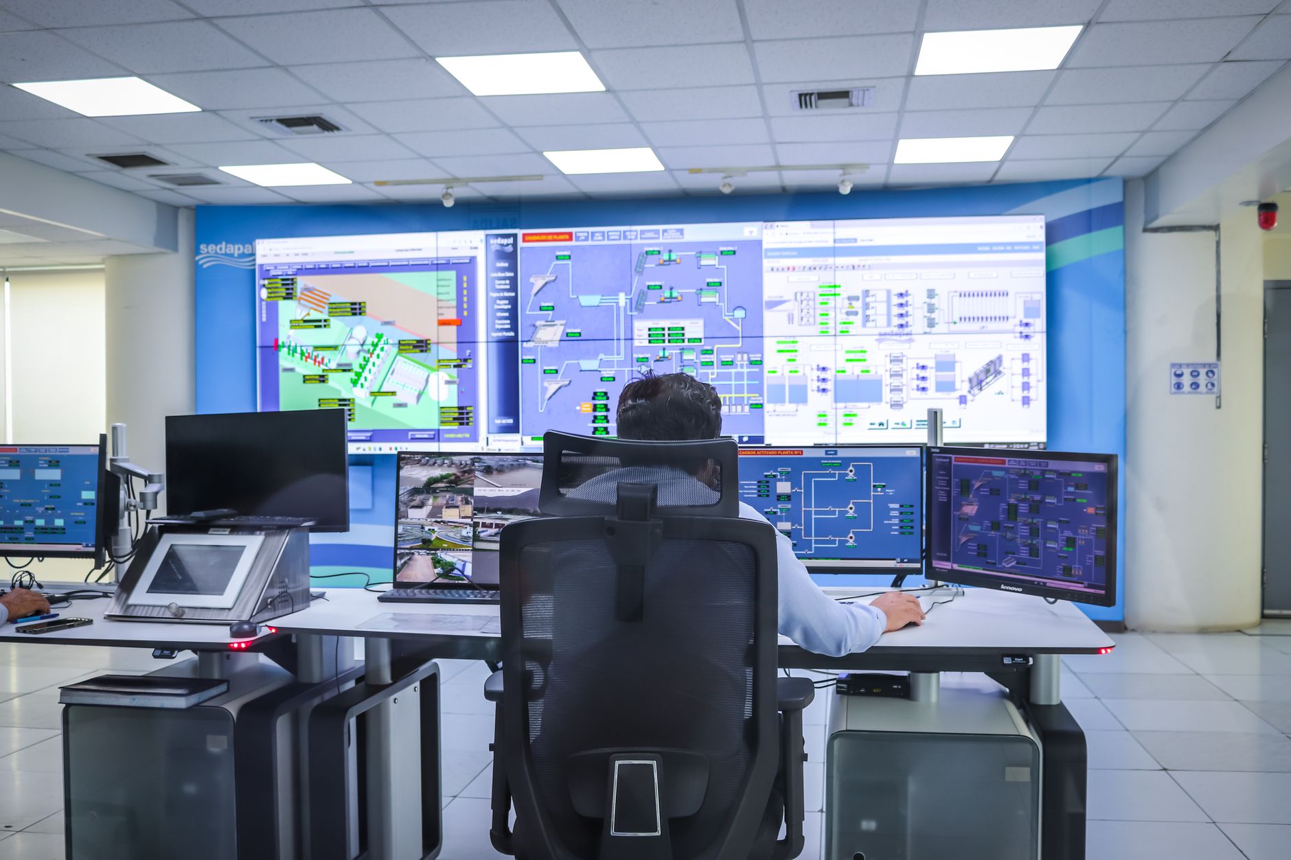 Opérateur dans une salle de contrôle moderne gérant des systèmes technologiques à El Agustino, Lima.