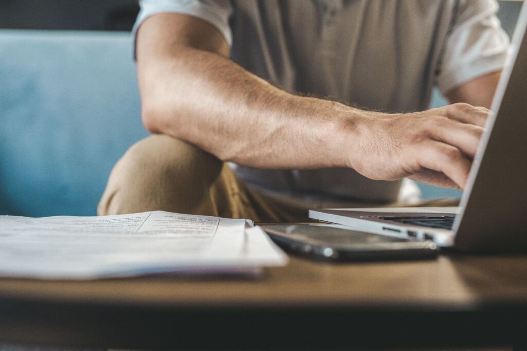 Un homme tapant sur un ordinateur portable à la maison, utilisant la technologie sans fil.