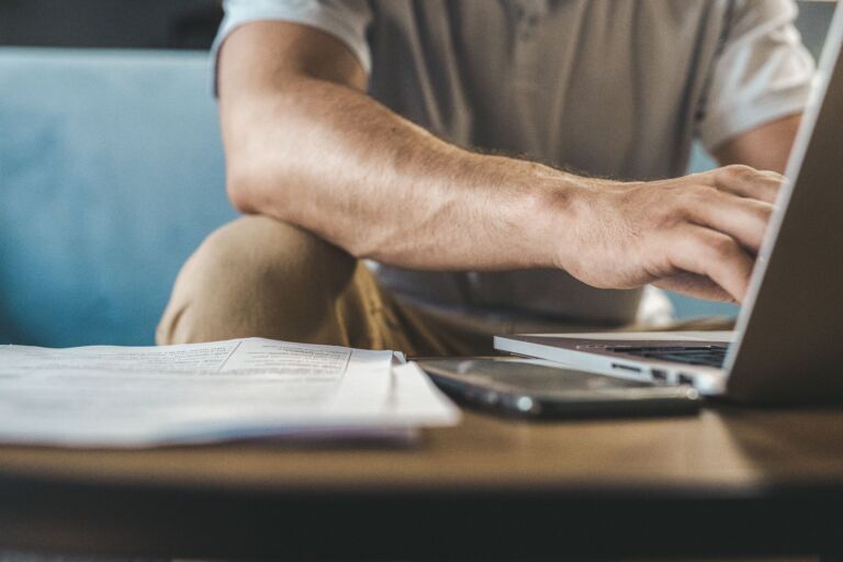 Un homme tapant sur un ordinateur portable à la maison, utilisant la technologie sans fil.