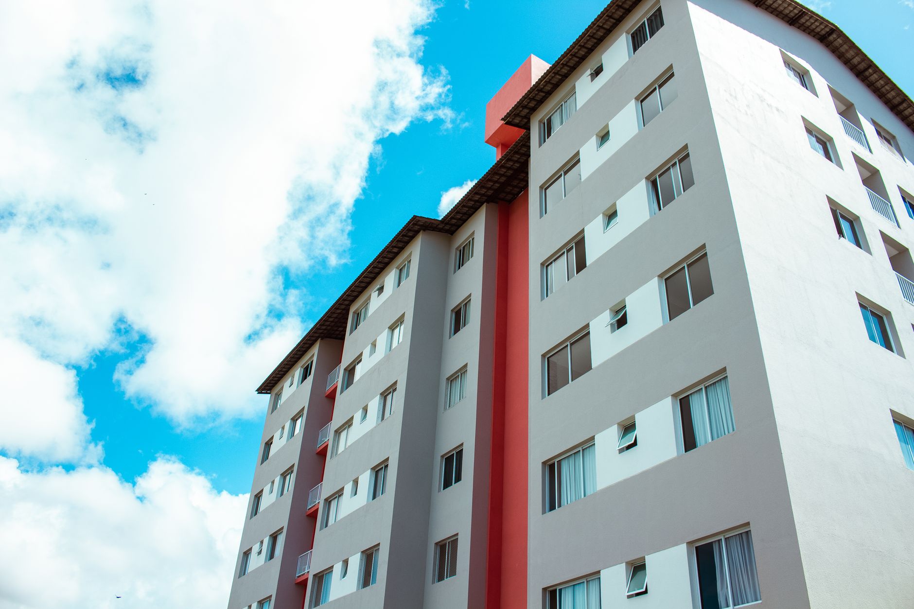 Immeuble résidentiel de grande hauteur sous un ciel bleu, mettant en valeur l'architecture moderne.