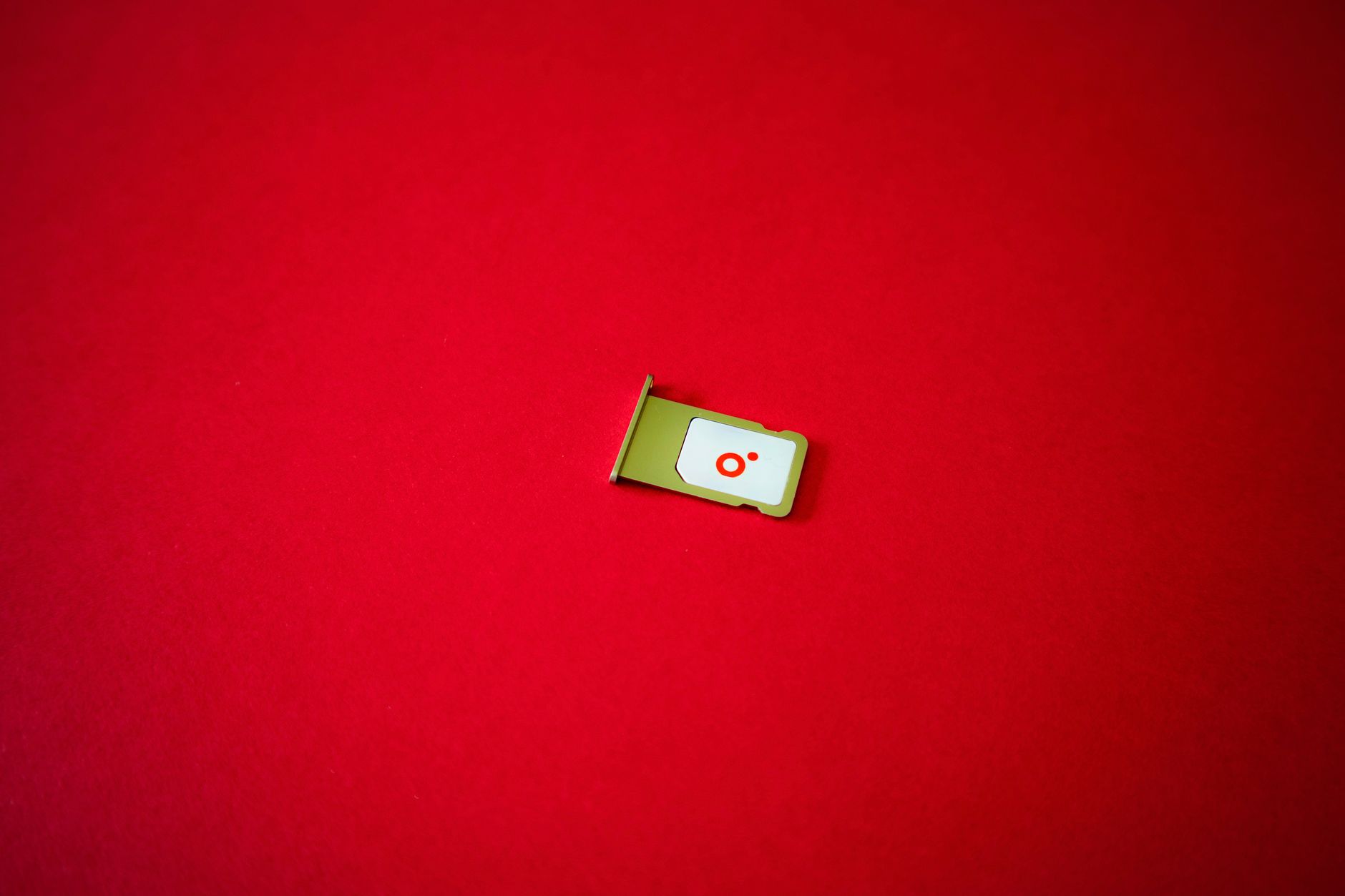 Une image claire d'un plateau de SIM affiché sur un fond rouge vif.