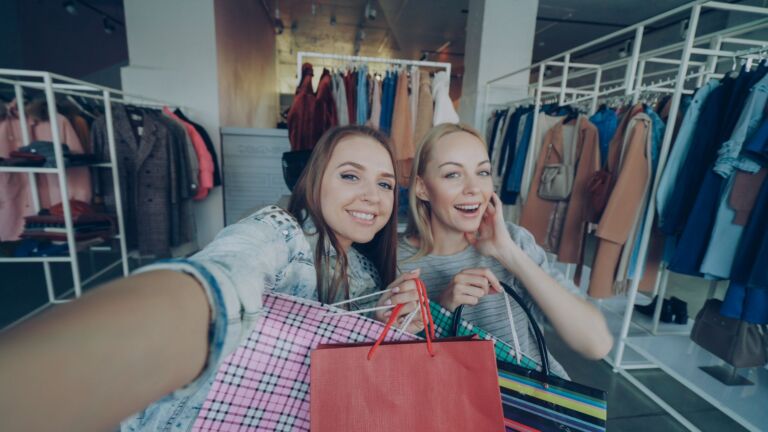 Deux femmes font joyeusement leurs achats avec leurs sacs dans un magasin de vêtements à la mode.